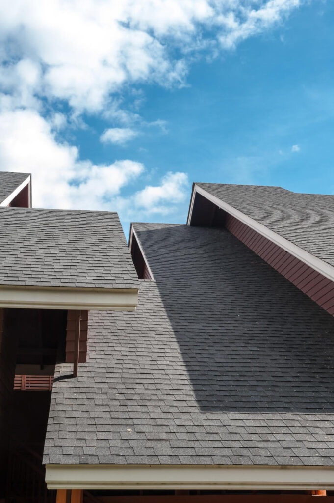 "High-quality shingle roofing installation on a residential property with clear blue sky background